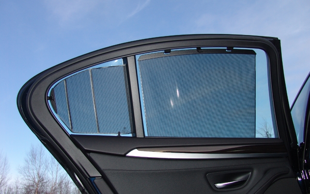 BMW 550xi 2011. Les stores des vitres arrières sont à commande manuelle.