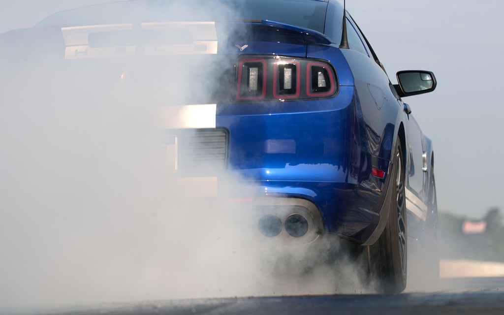 A Shelby GT500 warms up its tires before launching into the quarter mile