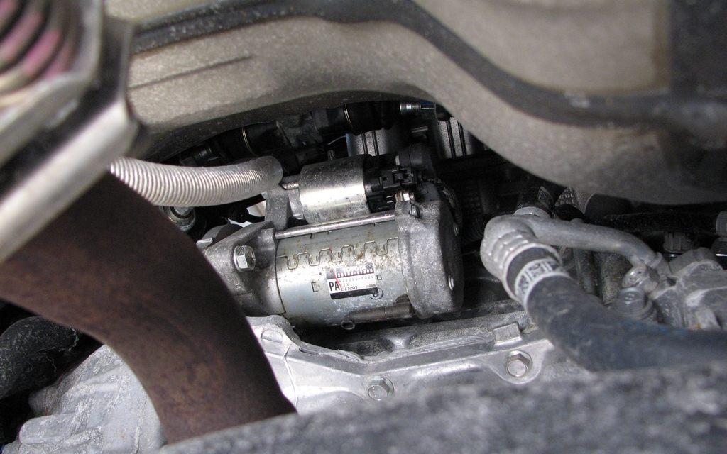 The starter is located in the very centre of the engine compartment.