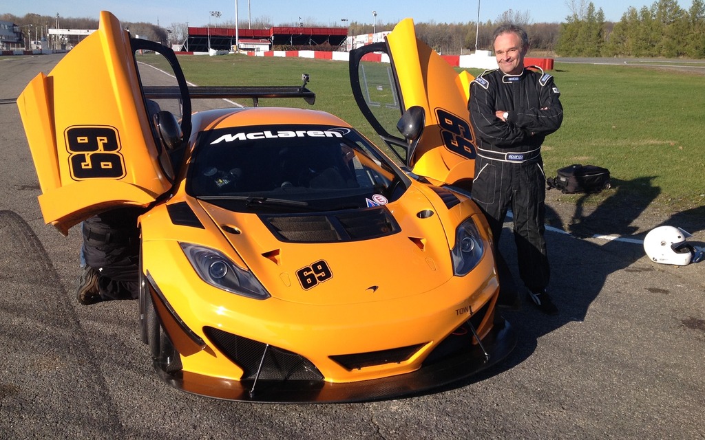 Marc Lachapelle in full race gear next to the McLaren 12C Can-Am Edition.