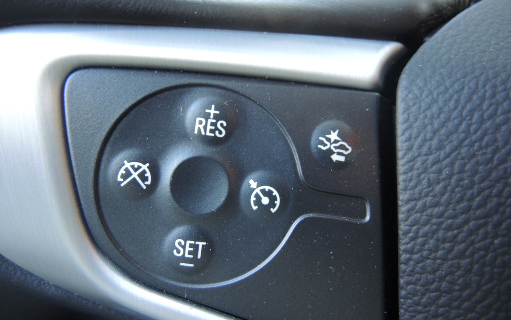 The cruise control buttons on the left spoke of the steering wheel.